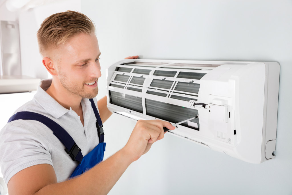 HVAC technician cleaning and repairing a ductless mini split AC in Brigham City, UT