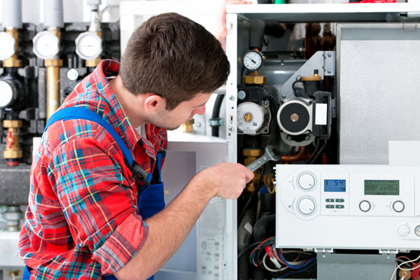 HVAC technician inspecting an indoor heating system in Brigham City, UT