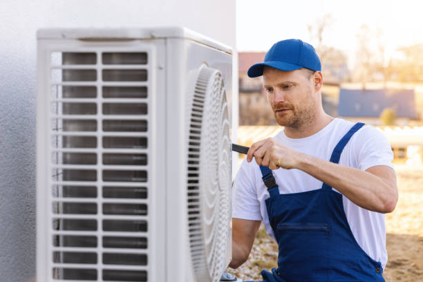 HVAC technician servicing an outdoor air conditioning unit in Brigham City