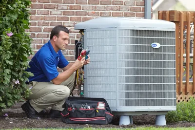 HVAC technician inspecting an outdoor air conditioning unit in Brigham City, UT